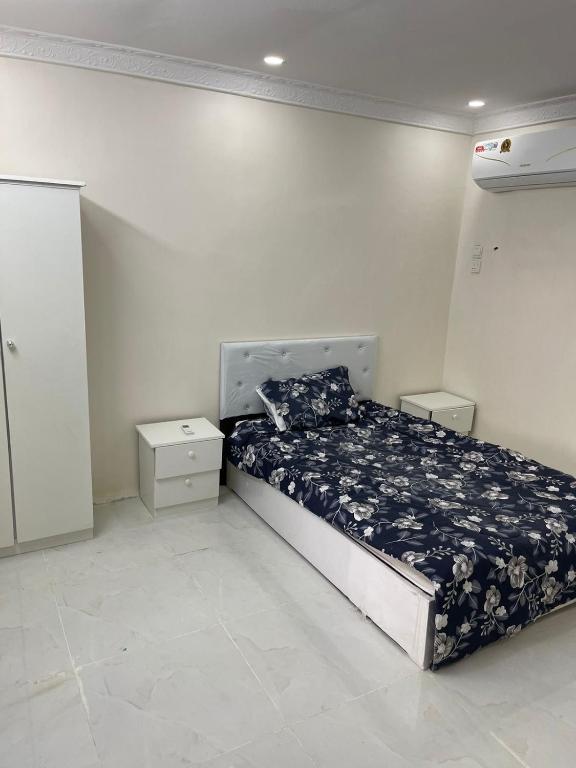 ein Schlafzimmer mit einem Bett und zwei Nachttischen in der Unterkunft شقق لمى للايجار in Al Bad‘