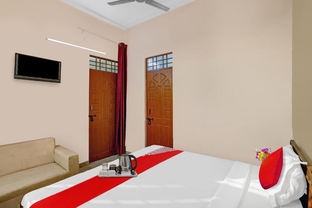 a bedroom with a bed and a television and a door at Flagship Sweet Homes in Ghaziabad