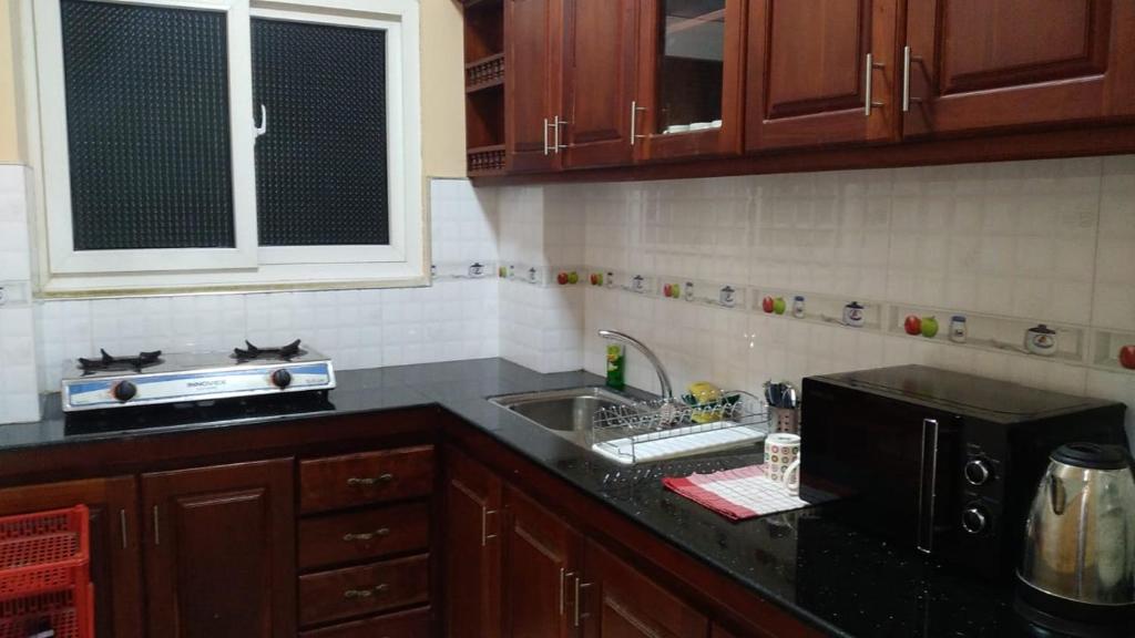 eine Küche mit Spüle und Mikrowelle in der Unterkunft MercuryFM 108 House - 24 Daya Road Colombo 6 -6-2 in Wellawatta