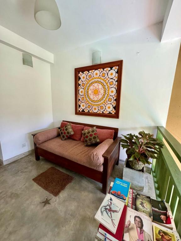 a living room with a couch and a picture on the wall at Aurora in Unawatuna