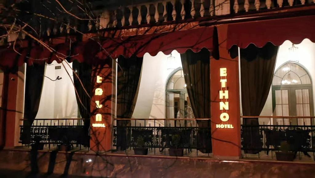 久姆里的住宿－Boutique ETHNO HOTEL，一座带窗户的建筑,上面有窗帘和标志