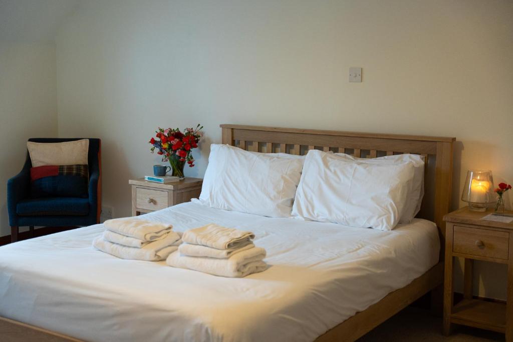 1 dormitorio con 1 cama con toallas en Woodlands House, en Ballachulish