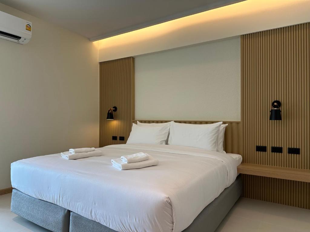 バンコクにあるJace hotelの大きな白いベッド(タオル2枚付)