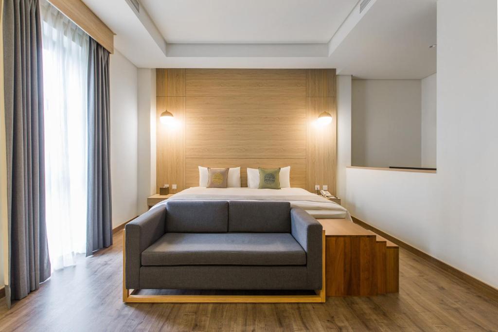 um quarto de hotel com uma cama e um sofá em Sun Dialogue Hotel-By Cosmos Creation em Chiayi City