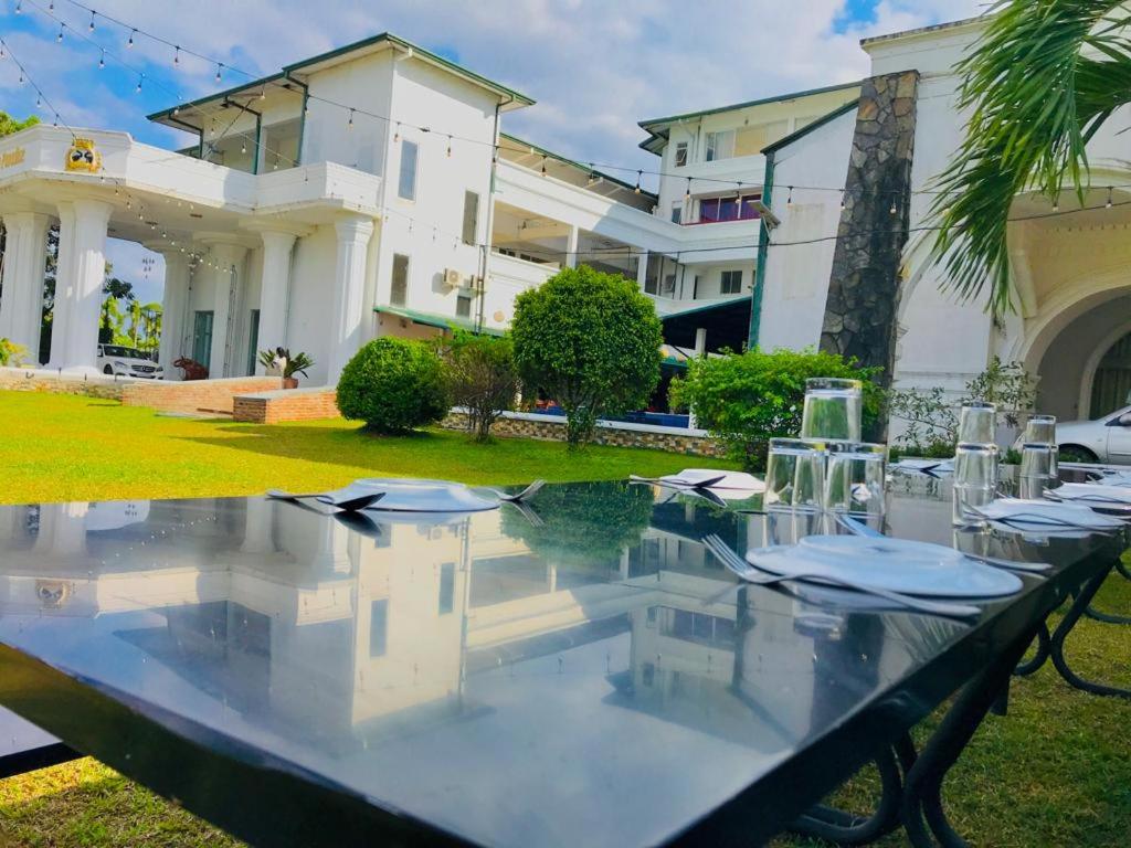a table with chairs in front of a house at Hotel Dream Paradise in Ja-Ela