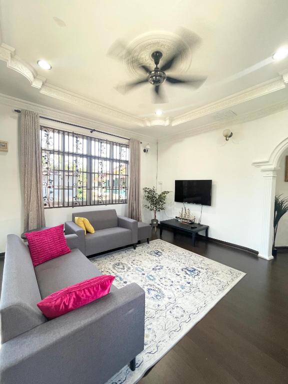 a living room with a couch and a television at Tokbah Homestay Alor Setar in Alor Setar