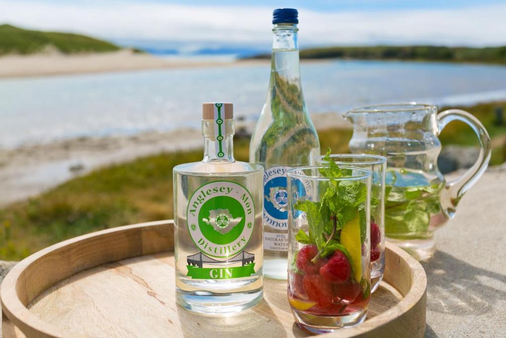 Ty Glan Y Mor في Aberffraw: زجاجة مياه ومشروب في كوب