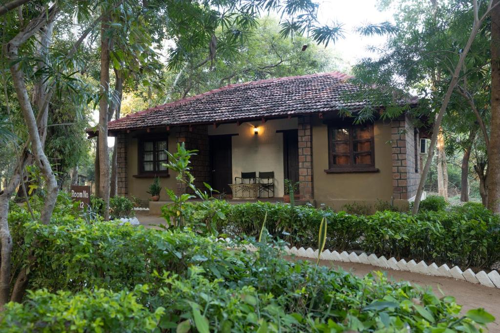 una pequeña casa en medio de un jardín en Tiger Trails Resort, en Tāla