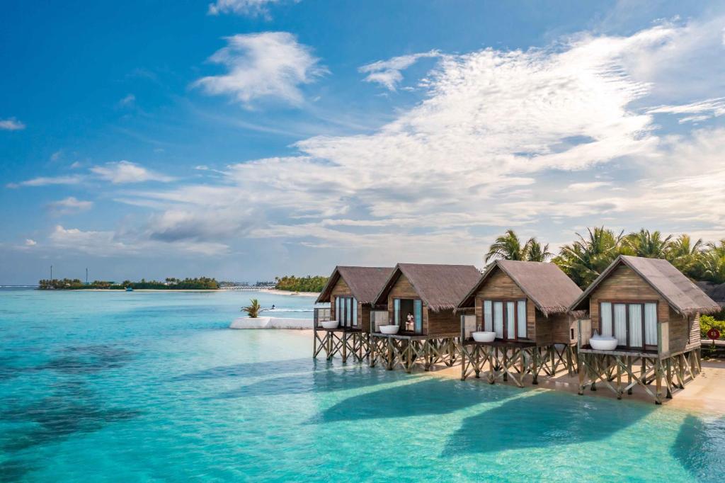 eine Reihe von Bungalows über dem Wasser auf einer Insel im Wasser in der Unterkunft OZEN LIFE MAADHOO - Luxury All Inclusive in Süd-Malé-Atoll