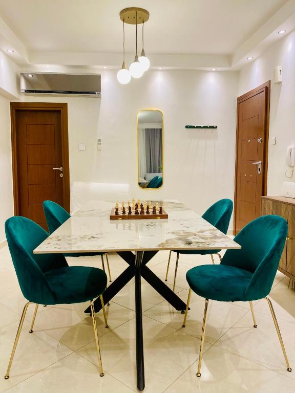een eetkamer met een schaakbord op een tafel met stoelen bij Orion White Tower Apartment in Thessaloniki