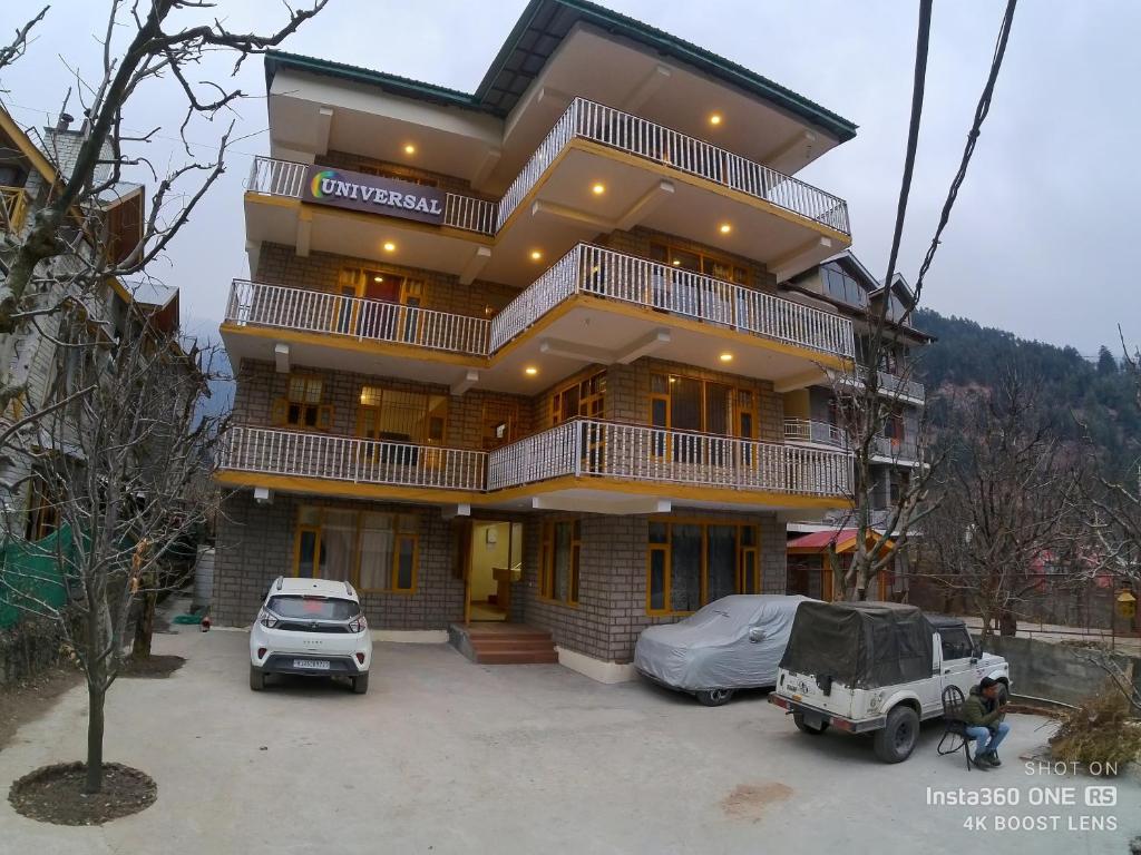 a large building with cars parked in front of it at Cloud 9 Chalet in Manāli