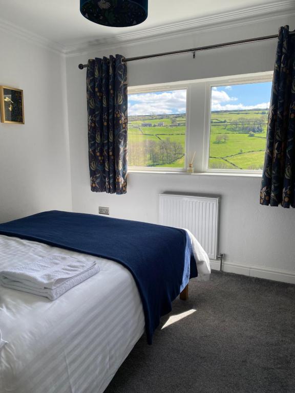 a bedroom with a bed and a large window at Holme Valley Vista, Holmfirth in Holmfirth