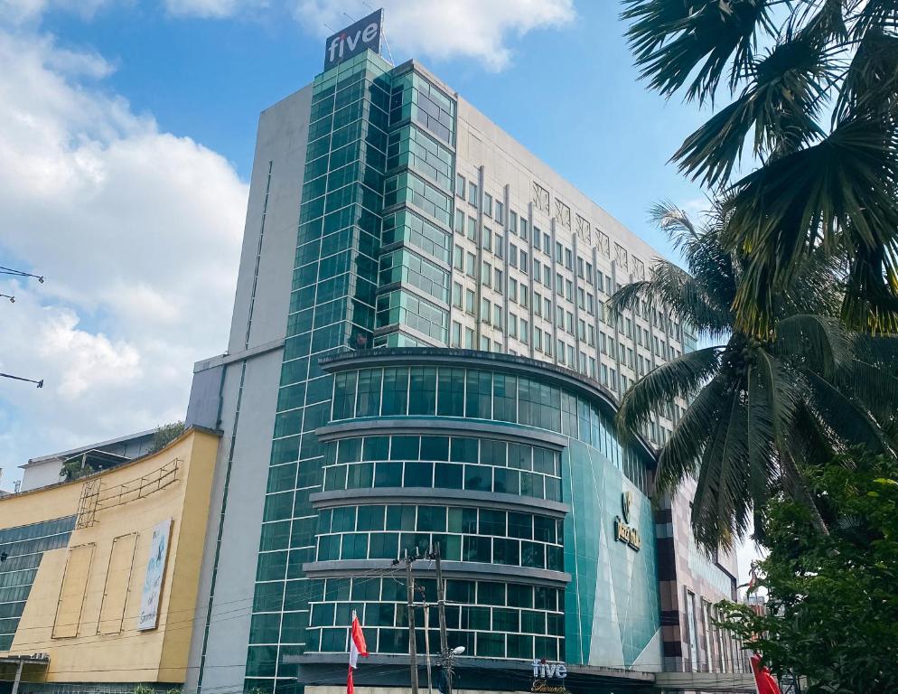 um edifício alto com um sinal em cima em Five Premiere Hotel em Samarinda