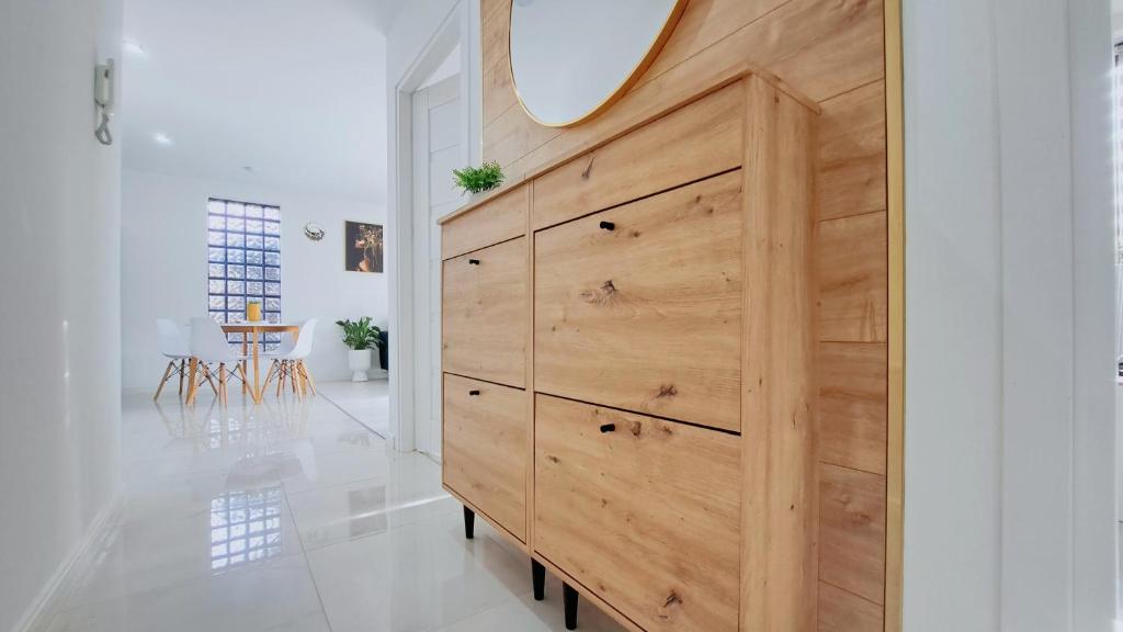 a large wooden dresser in a white room with a mirror at Wlodarska 4a Lux Premium in Kraków