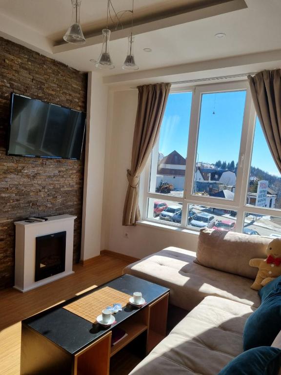 a living room with a couch and a fireplace at Apartman KUTIJA Kopaonik in Kopaonik