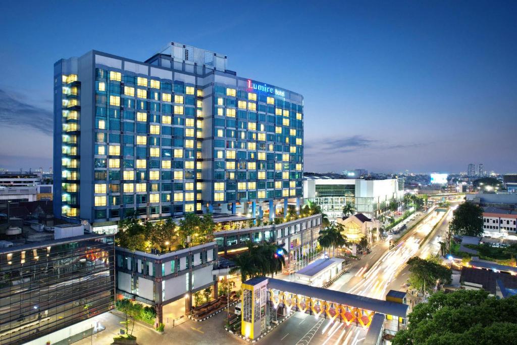 a tall building in a city at night at Lumire Hotel & Convention Centre in Jakarta