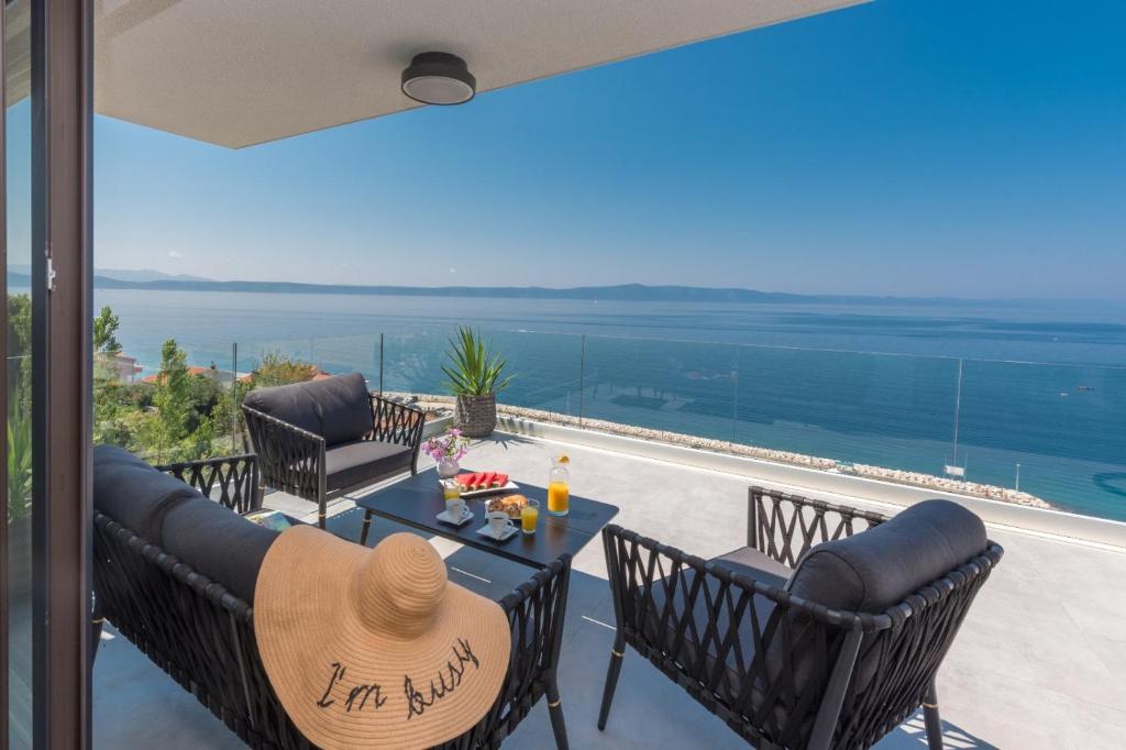 a patio with a table and chairs and a view of the ocean at Sun Paradise Apartment in Podgora