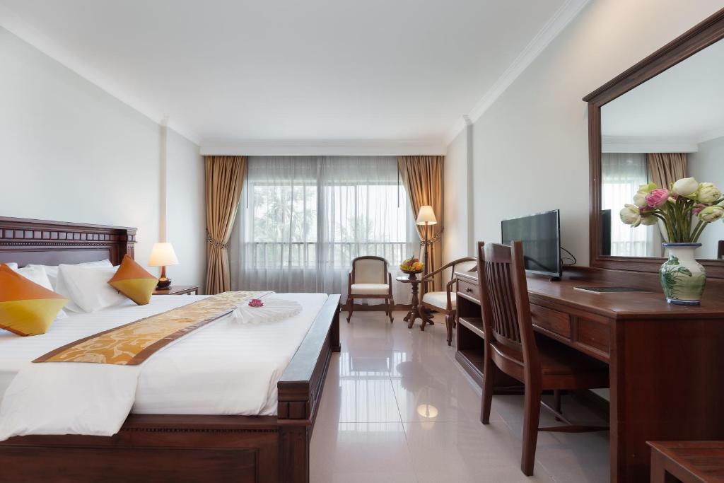 Postel nebo postele na pokoji v ubytování Monoreach Angkor Hotel