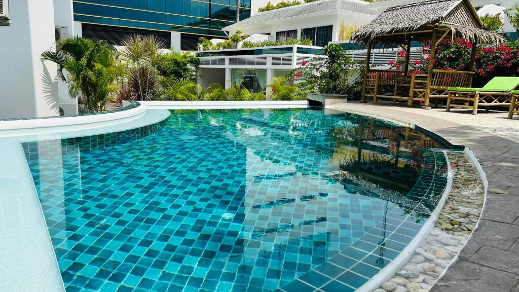 a large blue swimming pool next to a building at Crystal Bay Tropical Residence in Koh Samui 