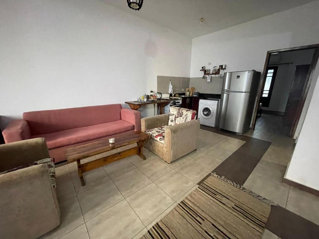 Lovely Chalet in Dahab في دهب: غرفة معيشة مع أريكة ومطبخ