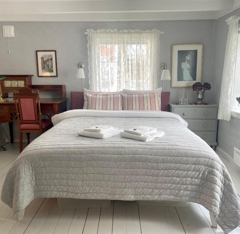 a bedroom with a bed with two towels on it at Reinertsenhuset in Skudeneshavn