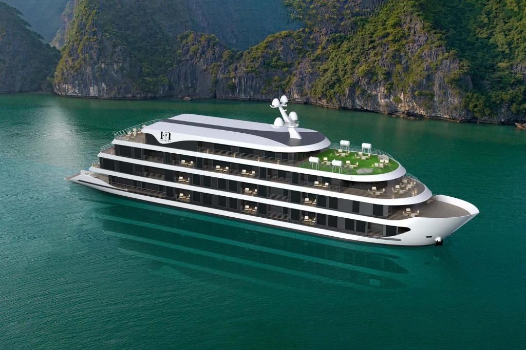 a cruise ship in a body of water with mountains at Era Premium Cruises Halong in Ha Long