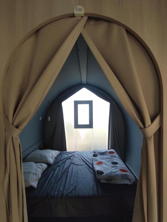 a bedroom with a canopy bed with a window at Family&#39;s Camping Le Savoy in Challes-les-Eaux