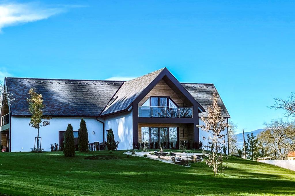 una gran casa blanca con techo de gambrel en KOASA HOF Bed and Breakfast, en Oberhaag