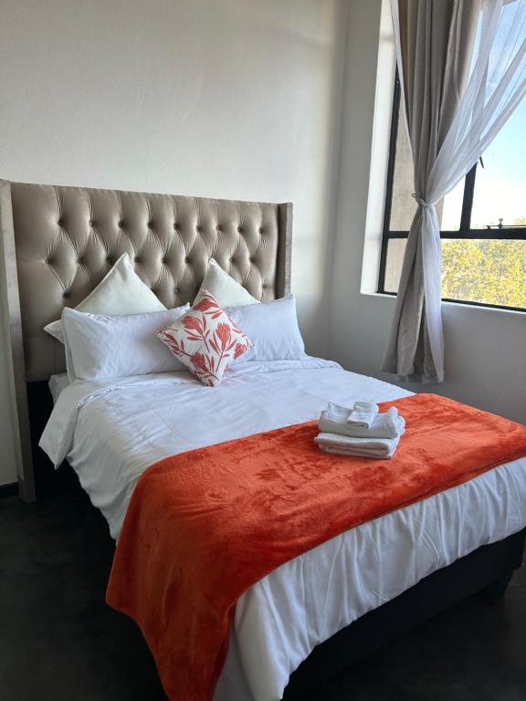 a bedroom with a large bed with a red blanket at 521 CityView Poised Paleis in Johannesburg