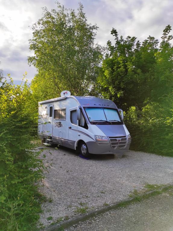 a silver rv parked in a gravel parking lot at Family&#39;s Camping Le Savoy in Challes-les-Eaux