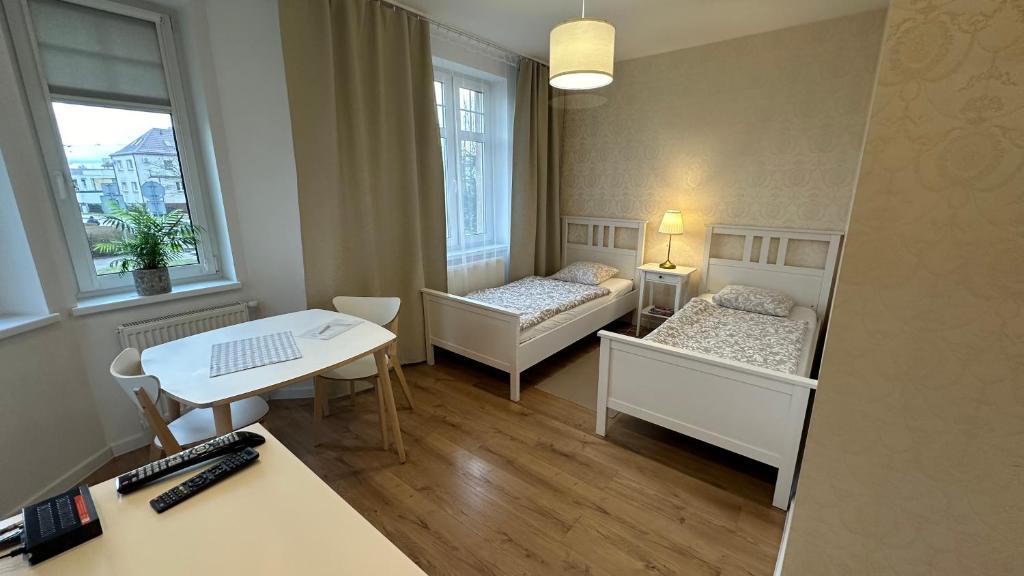 Mały pokój z 2 łóżkami i biurkiem w obiekcie Belgard- House 32 w mieście Białogard