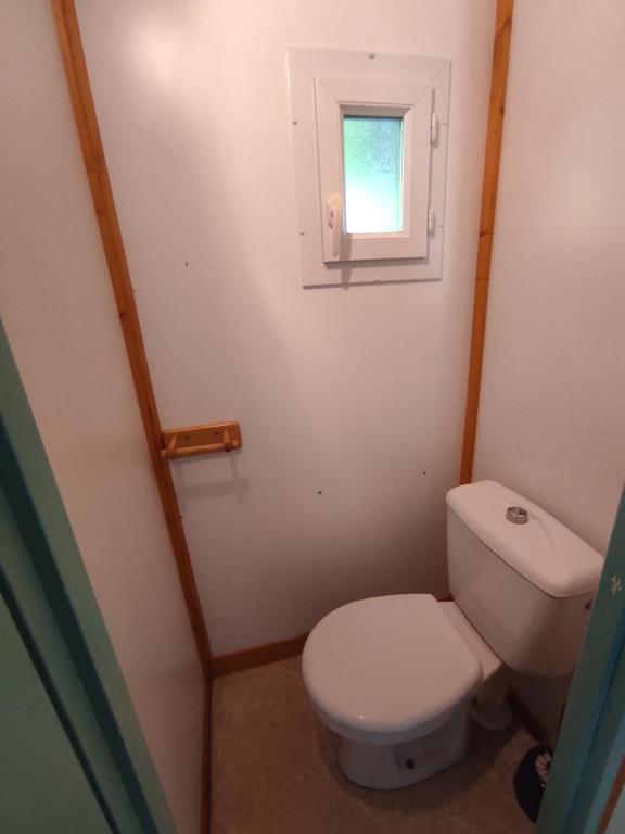a small bathroom with a toilet and a window at Family&#39;s Camping Le Savoy in Challes-les-Eaux