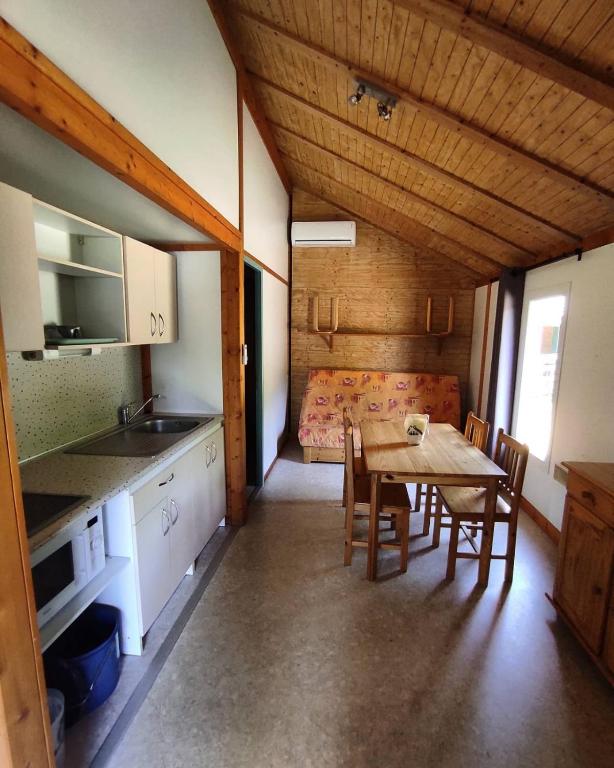 a kitchen and dining room with a table and a bed at Family&#39;s Camping Le Savoy in Challes-les-Eaux