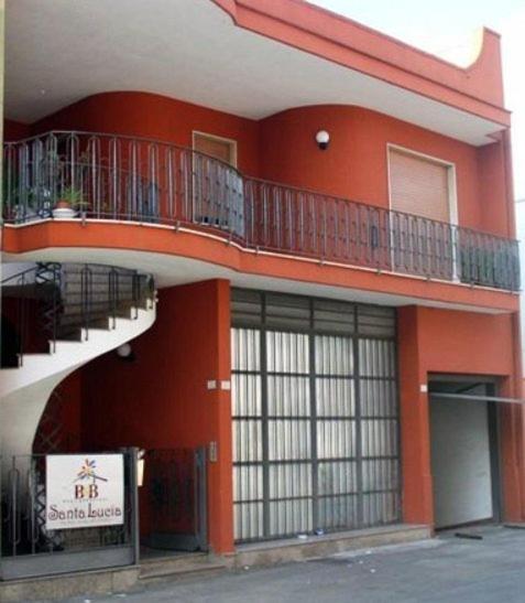 a red building with balconies on the side of it at B&B Santa Lucia in Sogliano Cavour