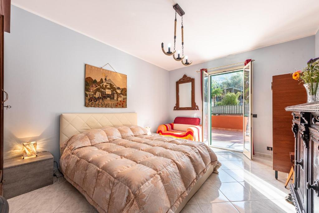 - une chambre avec un grand lit et une porte coulissante en verre dans l'établissement Casa Angelo, à Cefalù