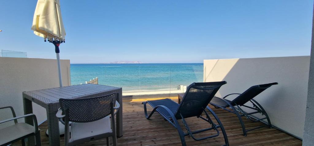 balcón con mesa, sillas y vistas al océano en Almare Beach Hotel, en Kokkíni Khánion