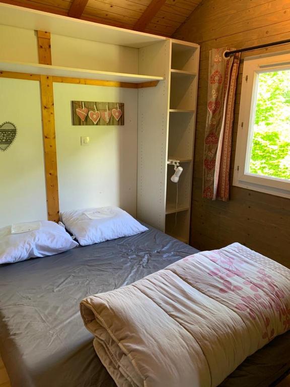 a bedroom with a bed in a cabin with a window at Family&#39;s Camping Le Savoy in Challes-les-Eaux