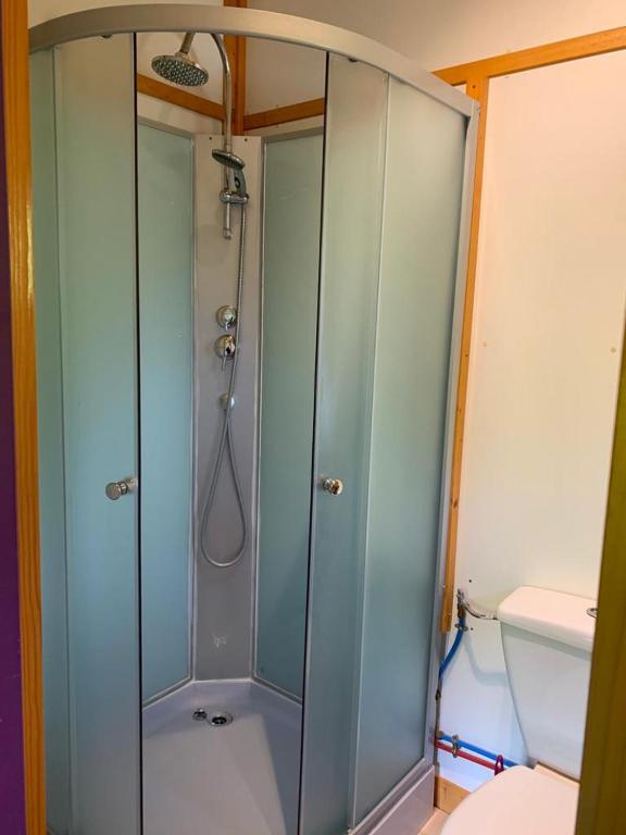 a shower with a glass door in a bathroom at Family&#39;s Camping Le Savoy in Challes-les-Eaux