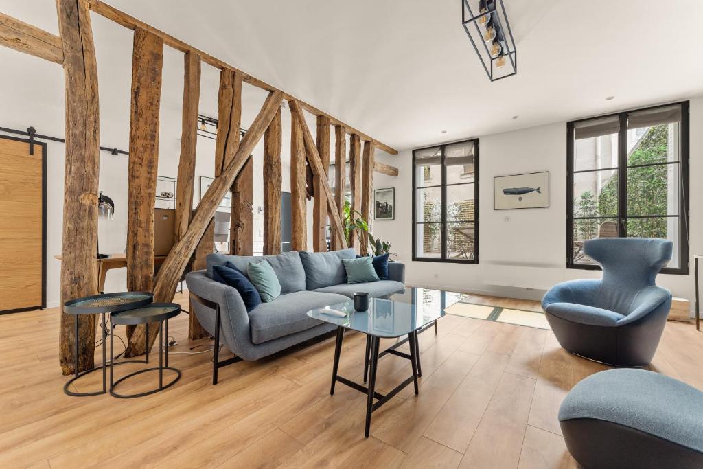 un salon avec un canapé bleu et des chaises dans l'établissement Francs-Bourgeois, à Paris