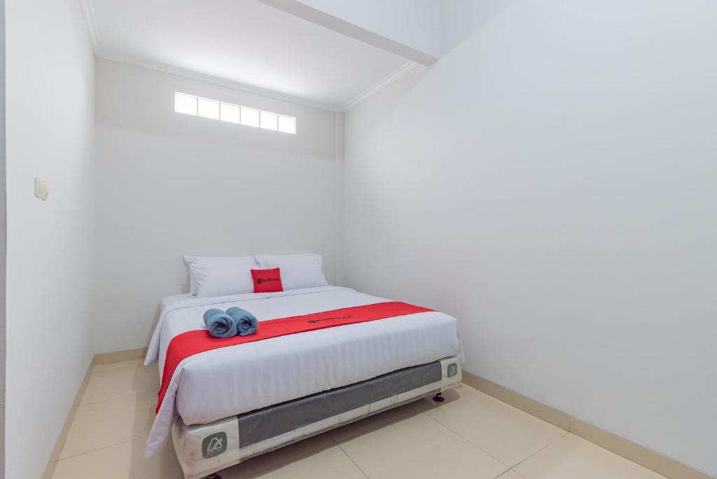 a white bedroom with a bed in a white room at Reddoorz near Kiara Artha Park in Bandung
