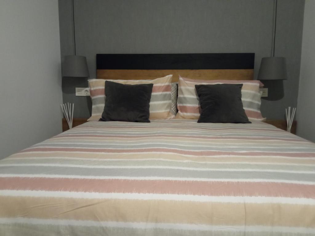 una camera da letto con un grande letto con due cuscini di LA BELLA MALAGUETA a Málaga
