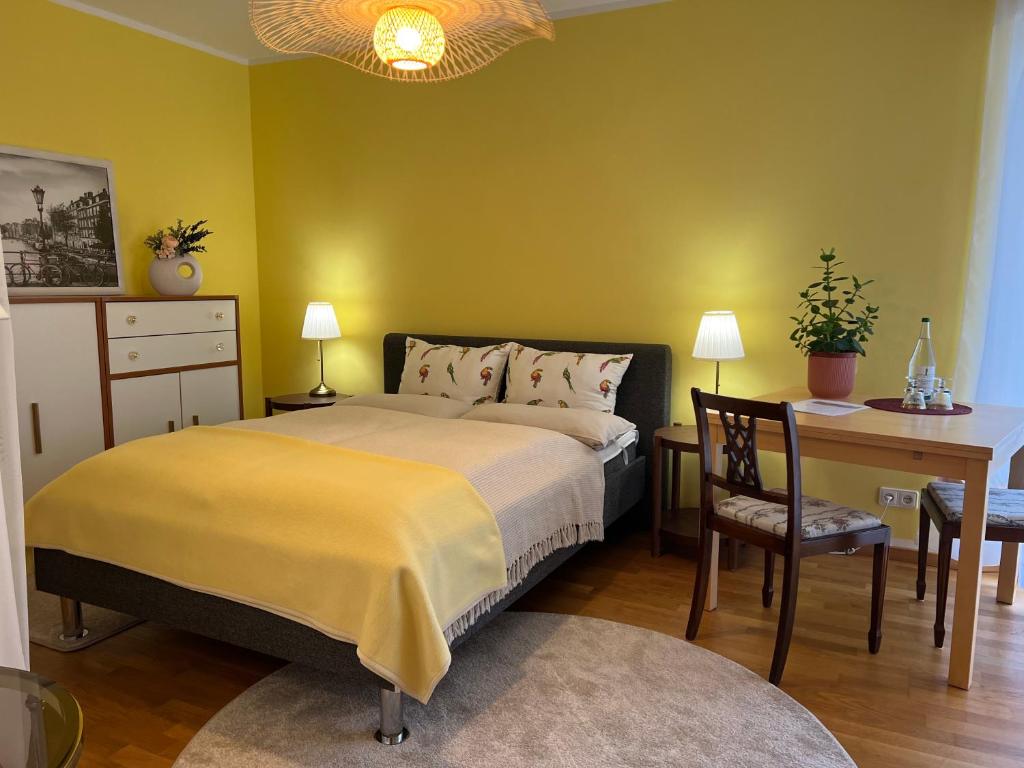 um quarto com uma cama, uma secretária, uma mesa e uma cadeira. em Privatzimmer mit Balkon em Munique