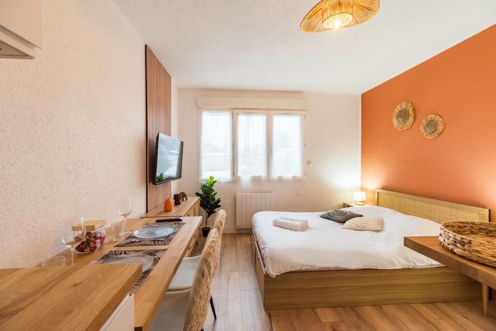 a bedroom with a bed and a table and a desk at Studio l'escale Bretonne - Saint-Brieuc in Saint-Brieuc