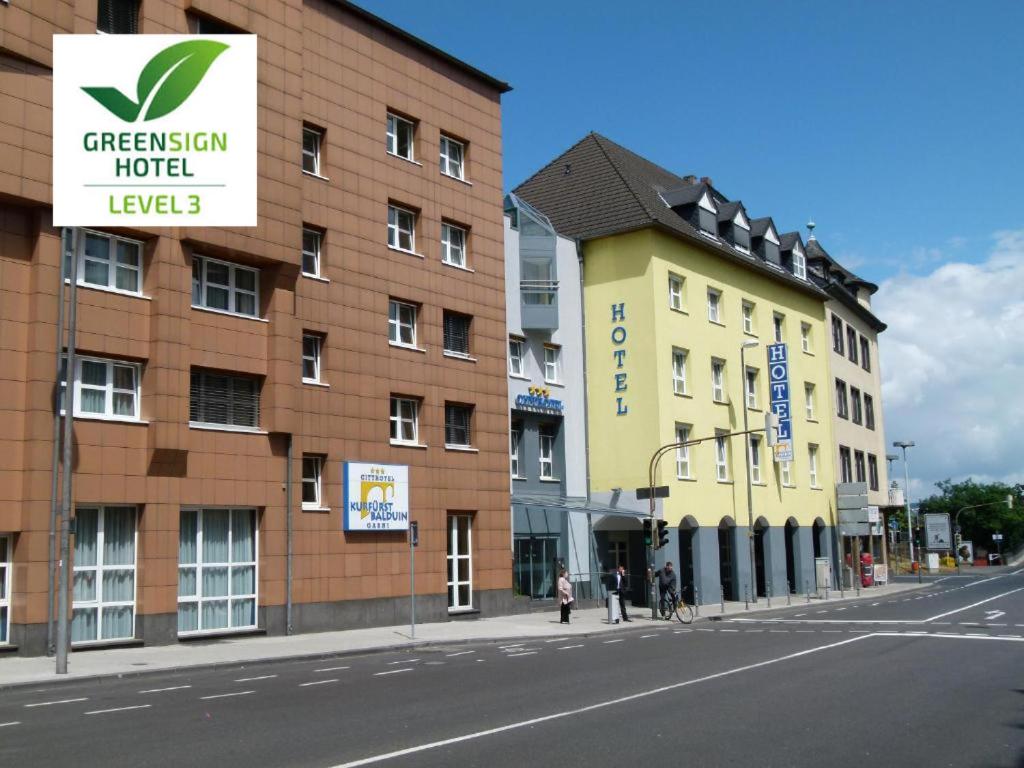 ein Gebäude auf einer Straße mit Leuten, die auf dem Bürgersteig laufen in der Unterkunft City-Hotel Kurfürst Balduin in Koblenz