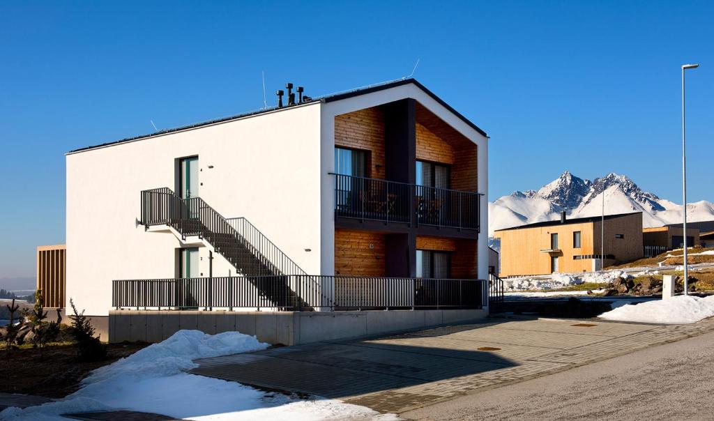 Royal Village - Royal Views apartments في Malý Slavkov: مبنى به درج وجبل مغطى بالثلوج