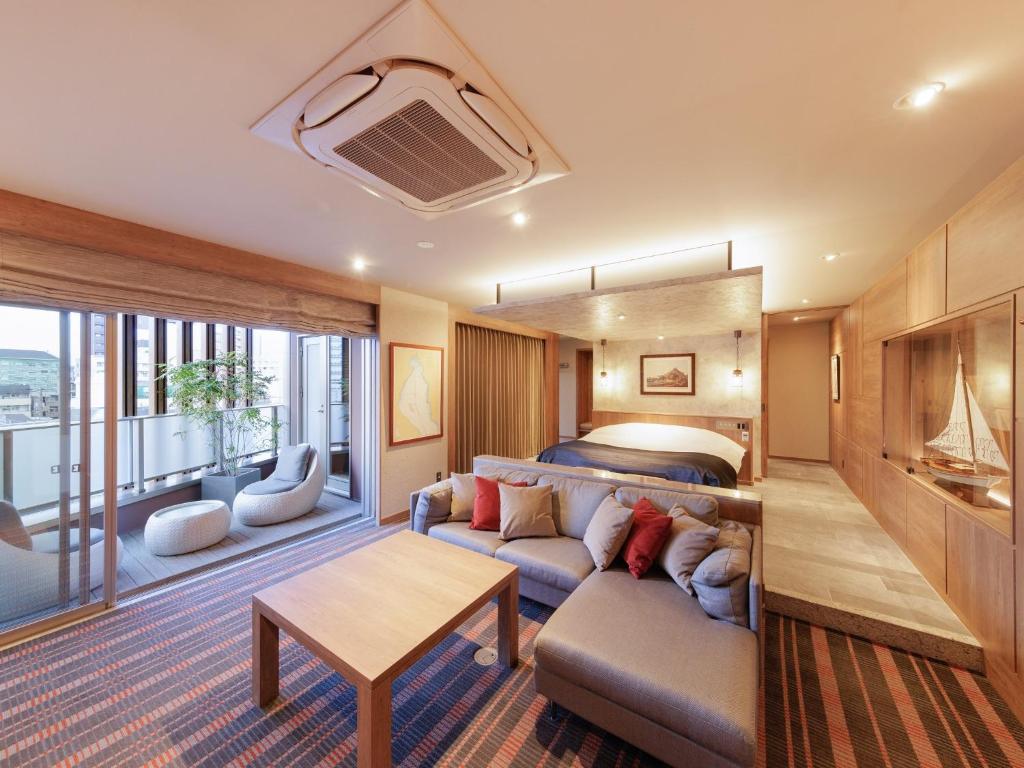 a hotel room with a bed and a couch and a table at Y-HOTEL - Vacation STAY 22285v in Hiroshima