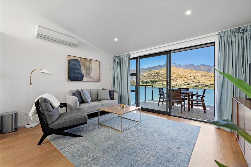 a living room with a couch and a table at Luxury Lakeside Retreat in Queenstown