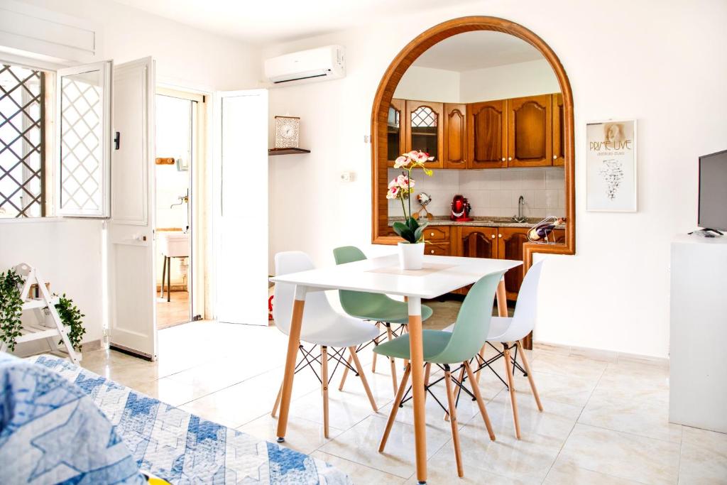 a kitchen and dining room with a white table and chairs at Casa Tridente - Meravigliosa villa sul mare in Torre Mozza