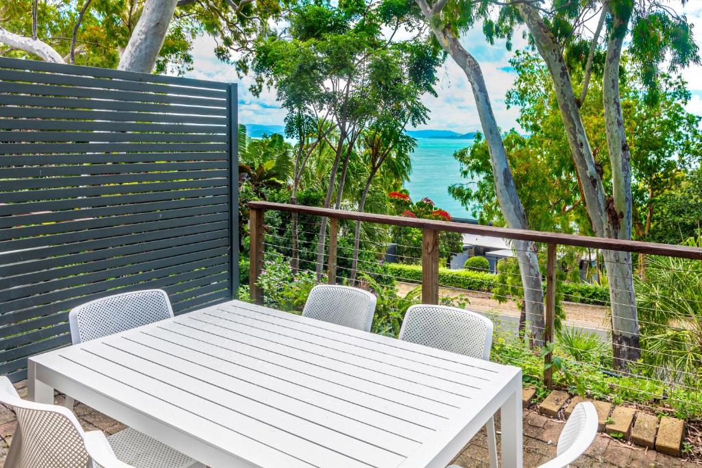 a white table and chairs on a balcony at Sunset Waters Apartments in Hamilton Island