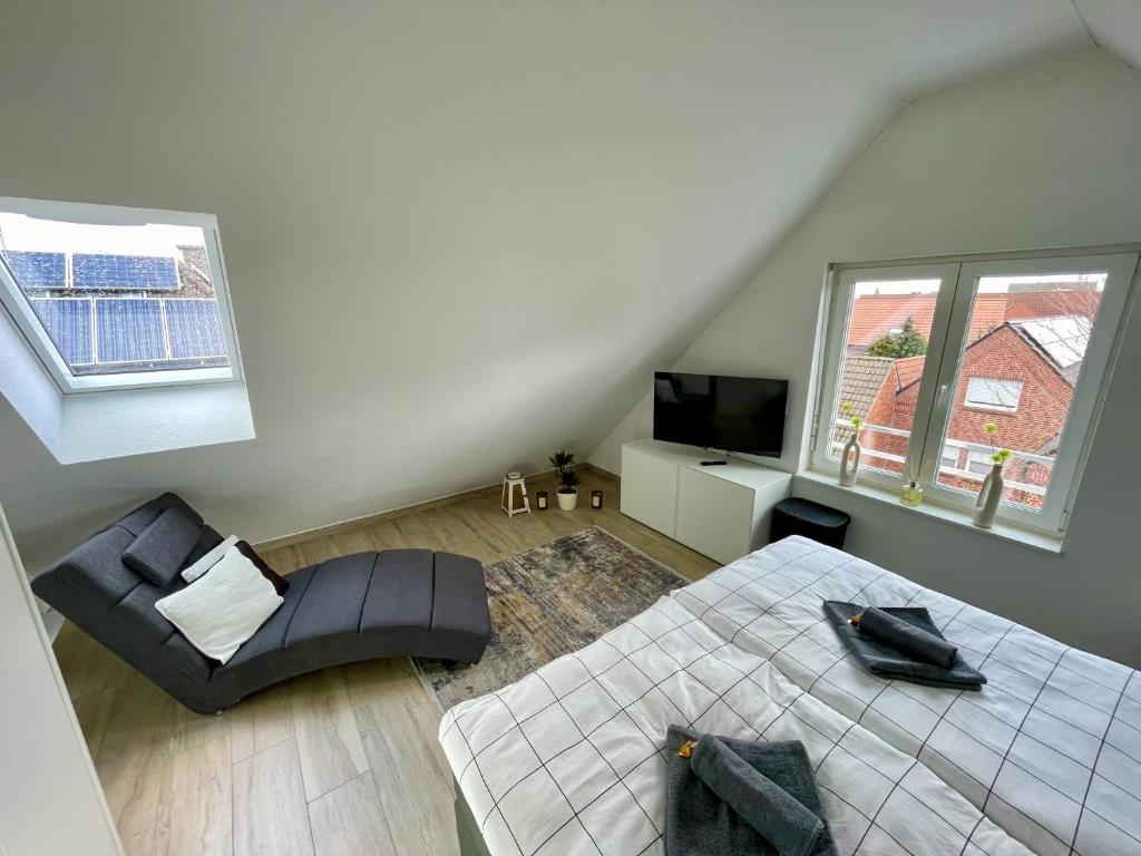 a bedroom with a bed and a chair and a television at Ahaus: Stadtoase mit Terrasse & privater Garage in Ahaus